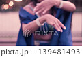 Beautiful Latina woman dancing belly dance in a park at sunset, wearing a blue dress, showing her hands, moving her hips, and wearing makeup. She dances smiling, with sensuality and joy. 139481493