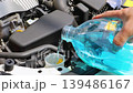 自動車のボンネットを開けてウィンドウォッシャー液を補充している 139486167