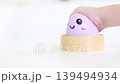 Child's hand playing with happy purple toy container 139494934