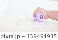 Child hand squeezing purple smiling dumpling squishy 139494935