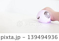 Child hand squeezing purple smiling dumpling squishy 139494936
