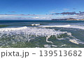Wide Coastal View With Crashing Waves Greenblue Water And Foamy Surf, Distant Seaside Town On Headland 139513682