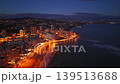 Night Coastline Lit By City Lights, Glowing Boulevard, Highrise Hotels With Reflected Light On Water, Traffic 139513688