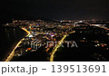 Aerial Night Coastline City Lights Glittering Along Shore, Drone Glides Over Quiet Beach And Illuminated 139513691