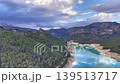 Aerial View Turquoise Reservoir Winding Through Pine Forest And Rugged Mountains Under Dramatic Cloudscape, 139513717