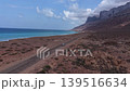 White car driving on coastal road in arid landscape, socotra island 139516634