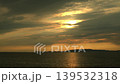 The sea at sunset illuminates the isolated island, a poignant scene. 139532318