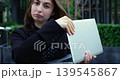 Caucasian woman outdoor closing laptop, blazer and polka blouse, assertive swipe and dismissive facial expression, urban courtyard environment, brief frustrated gesture during hybrid work routine 139545867