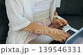 Woman making online payment. Individual completes digital transaction at home using credit card. Person performs online purchase by entering details on laptop with payment papers nearby 139546331
