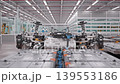 Crane shot of Electric Car Chassis loaded on AGVs in Fully Automated Modern Autonomous Electric Car Factory. AI-powered Humanoid Robots and Robotic Arms  in Background. 3d Animation Render 139553186