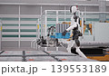 Parallel Tracking Shot of an AI-powered Humanoid Robots Walking and Carrying Crates with Lithium-Ion Battery Modules in a Fully Automated Car Factory with AGVs and Robotic Arms. 3d Animation Render 139553189
