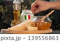 Composition conveys Italian agro and gastro tourism through rich display of premium cheese, honey, and dairy products, evoking travel, tradition, and authentic countryside cuisine. 139556863
