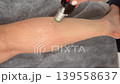 close up of woman leg receiving alexandrite laser hair removal professional cosmetologist performing epilation with modern cooling handpiece in aesthetic clinic 139558637