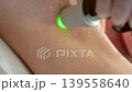 Vertical frame close up of alexandrite laser hair removal on female armpit area professional cosmetologist treating skin with cooling laser handpiece in aesthetic clinic 139558640
