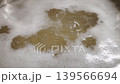 Close-up view of bubbling liquid in a pot with foam forming on the surface, showcasing the gradual movement and texture of the mixture in a kitchen setting 139566694