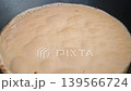 Boiling milk in a black frying pan creates frothy bubbles, showcasing the gradual rise and texture change of the liquid in a kitchen setting 139566724
