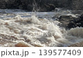 Amazing shot of fast flowing water and the rocks around it on a sunny day. Geology shot with the camera slowly moving downwards. 139577409