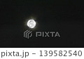 A captivating image of a bright full moon shining in the night sky. The soft halo effect adds a unique glow, emphasizing the beauty of the celestial scene. 139582540
