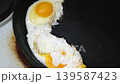 making fried eggs for breakfast 139587423