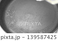 pour oil into a hot frying pan on an electric stove 139587425