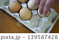 takes a few eggs from the package 139587428