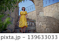 Brunette Woman in Hat Descending Stone Stairs Under Blue Sky 139633033