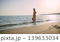 Brunette Woman Standing in Sea at Sunset Looking at Camera, Copy Space 139633034