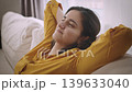 Happy Young Brunette Woman Relaxing on Sofa at Home in Daylight 139633040