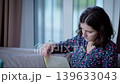 Woman spends her time reading a book while sitting on the sofa at home 139633043