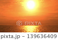 The sea and horizon are bathed in a dramatic sunset. 139636409