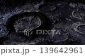 A breathtaking lunar surface reveals deep craters and rugged terrain illuminated by faint light. The dark expanse is a marvel of celestial geography, showcasing the moons intricate details. 139642961
