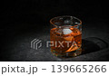 Bartender garnishing a Manhattan cocktail with an orange peel in an extreme close-up shot against a dark background 139665266