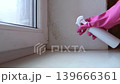Person in pink gloves cleaning mold on window sill and walls using antifungal spray. Removing toxic black mold and mildew from window frame and plaster. Home maintenance and hygiene. Person in pink gloves cleaning mold on window sill and walls using antifungal spray. Removing toxic black mold and mildew from window frame and plaster. Home maintenance and hygiene. 139666361