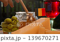 Belgian cheese, honey, and olives are arranged with rustic elegance beside rich red wine, creating warm European food travel atmosphere. 139670271