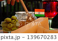 Rich Indian farm produce, including cheese, honey, and dairy goods, is shown in a warm rustic setting with red wine. 139670283