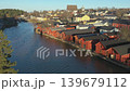Porvoo.Finland-December 12.2020: Red houses next to the wide river with forest in the background in Porvoo Finland with cars passing in shadows during a sunny day 139679112