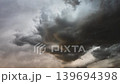 Moody thunderstorm clouds forming overhead in turbulent atmospheric sky 139694398