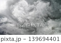 Grey thunderstorm clouds rolling overhead in an ominous weather sky scene 139694401