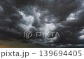 Fast moving rain clouds sweeping across an ominous grey stormy sky scene 139694405