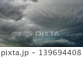 Dark rain clouds gathering and shifting in an intense weather sky scene 139694408