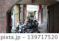 A covered walkway in Taipei with lots of parked motorcycles. 139717520