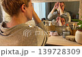 Woman Practicing Facial Yoga in Front of Mirror Woman Practicing Facial Yoga in Front of Mirror 139728309