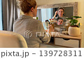 Woman Practicing Facial Yoga in Front of Mirror Woman Practicing Facial Yoga in Front of Mirror 139728311
