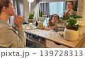 Woman Practicing Facial Yoga in Front of Mirror Woman Practicing Facial Yoga in Front of Mirror 139728313