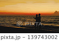 A married couple spends time at the beach as the sun sets. They fly a kite together and share moments of joy. The waves gently touch the shore as they enjoy their honeymoon. High quality 4k footage 139743002