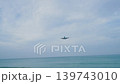 Airplanes approach the airport while flying over a beach. Waves crash on the shore as the planes land. Clouds fill the sky during the afternoon time. High quality 4k footage 139743010