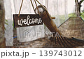A wooden bamboo welcome sign next to a woven hammock in a tropical garden with green plants and natural light for relaxation. High quality 4k footage 139743012