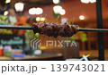 A close-up view of grilled meat on a spit at a Thai night market shows the cooking process in action. The kebabs are served to hungry customers at night. High quality FullHD footage 139743021