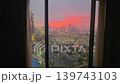 city sunset through a high hotel window, travel video frame with orange sky, towers, streets and evening urban view 139743103