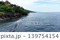 Traditional Jukung Boat Cruising Past Rocky Coastline in Amed Bali 139754154